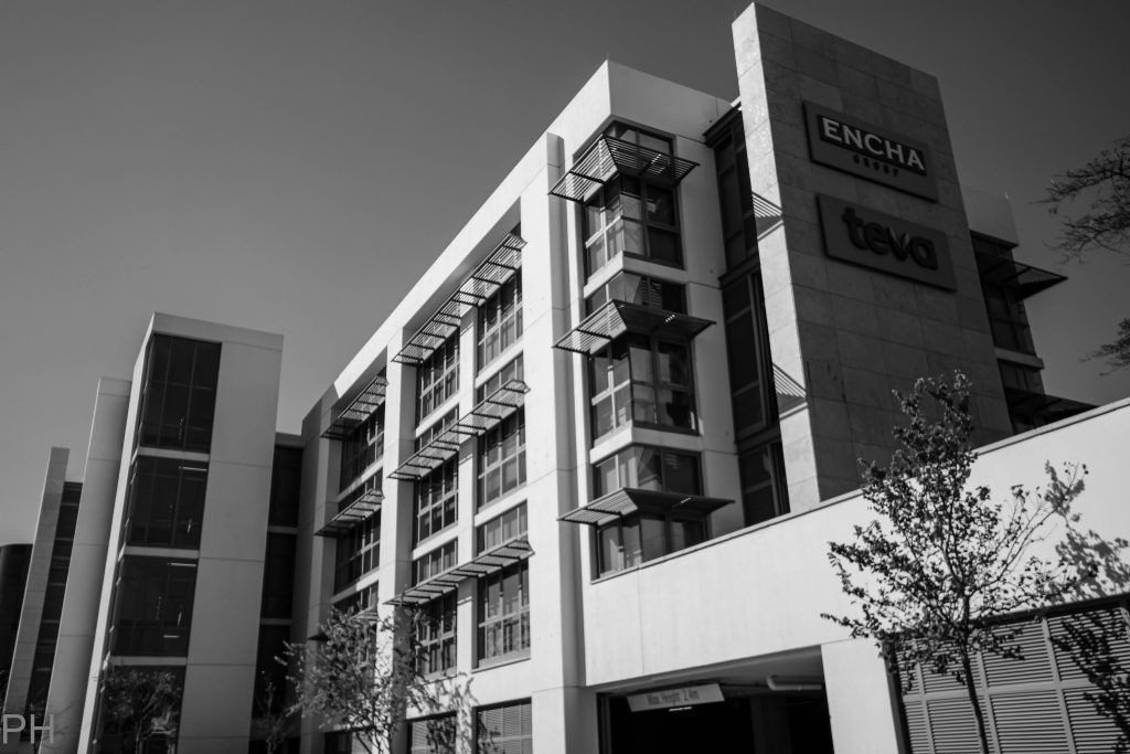 Black and white image of an office building in the sunlight, demonstrating commercial property